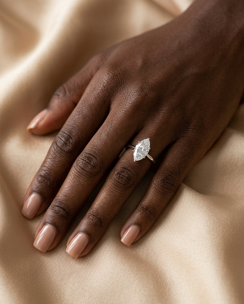 Mira marquise ring on a model's hand — top-down on silk