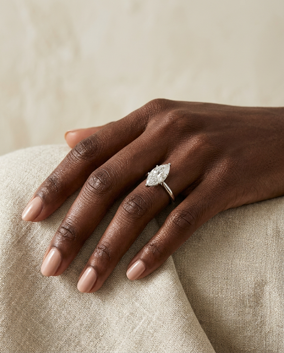 Mira marquise ring on a model's hand resting on linen